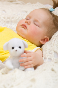 婴儿睡在她的熊玩具上