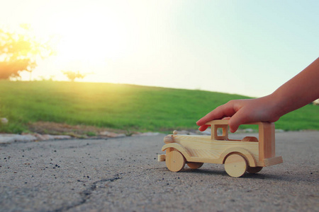 小孩在玩户外在公园的道路上的木制玩具车