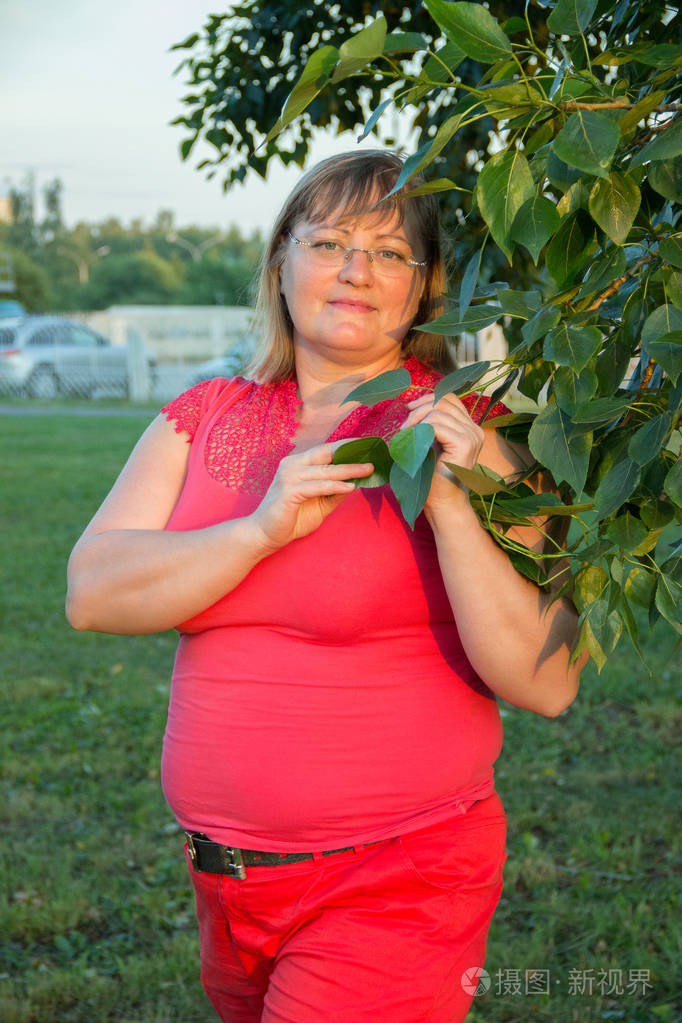 肥胖的女人在红色牛仔裤与词中的大肚皮的肖像