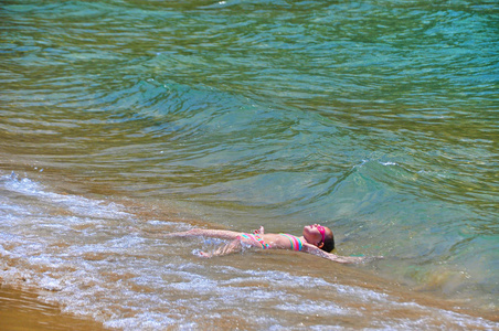 这个女孩正躺在大海等待一波波