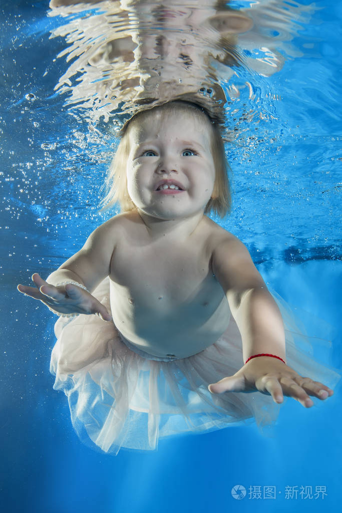 小女孩学会水下在游泳池里游泳