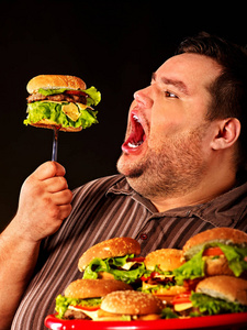 胖子吃快餐汉堡。早餐为超重的人的