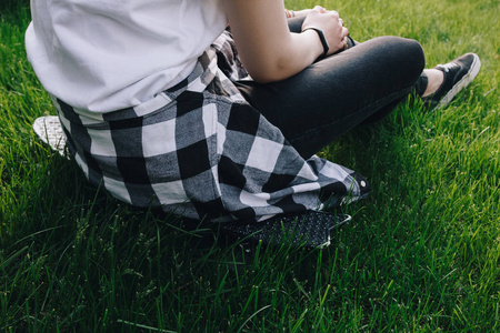 时髦女孩坐在草地上