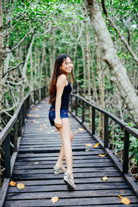 在红树林森林木桥的年轻漂亮的女孩肖像
