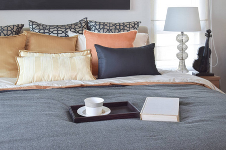 现代居室室内装饰木制托盘上茶杯与白书在床上