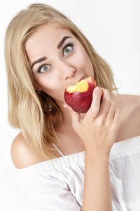 美丽的金发女人，欣然吃油桃