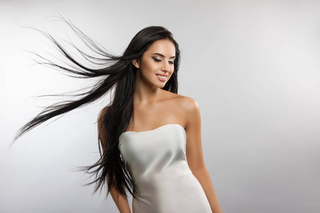 美丽的女孩模型与飞舞的风头发照片