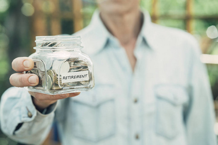 女人手里拿着玻璃罐里的钱 硬币  财务概念  快乐退休