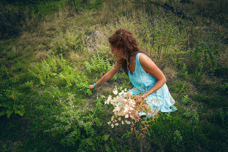 年轻女人作弄清洁野山居民区的草药和花