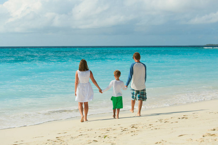 家庭与孩子在沙滩上行走