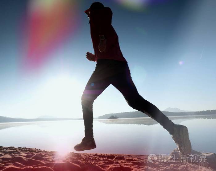 剪影的现役运动员赛跑者在日出海岸上运行。健康的生活方式晨练