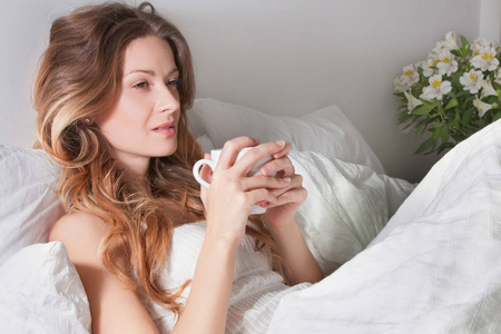 女人躺在床上杯咖啡