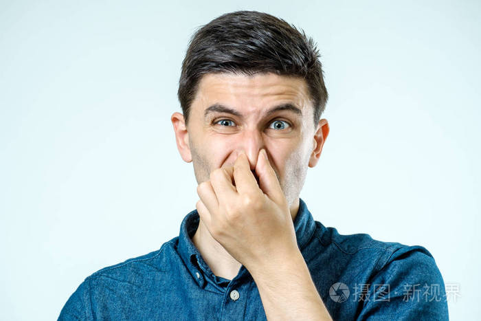男人捏着鼻子对难闻的气味
