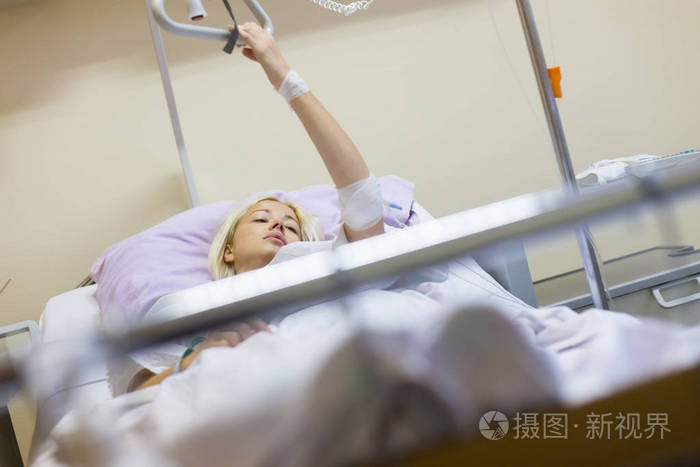 卧病在床的女病人,在医院照顾手术后恢复