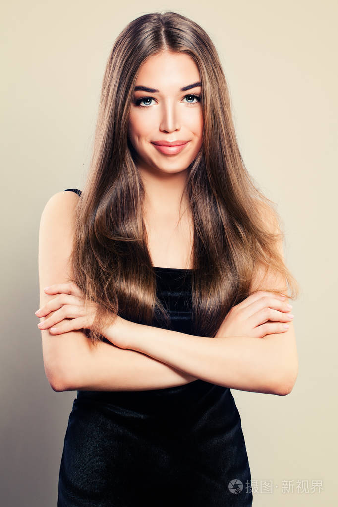 年轻的可爱女人穿件黑衣服.小女孩微笑着用双臂交叉