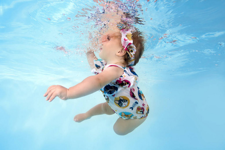 小女孩游在池中的水