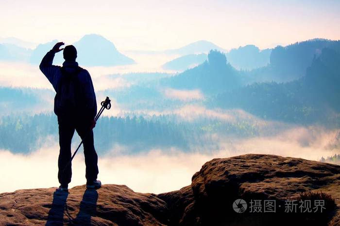 在洛矶山脉有雾的日子旅游与剪影手杆徒步旅行者站在岩石看法点上方