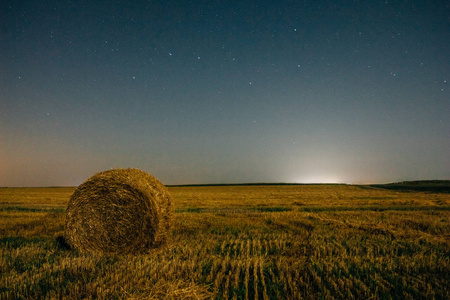 干草堆里的干草在夜空下的乡村景观