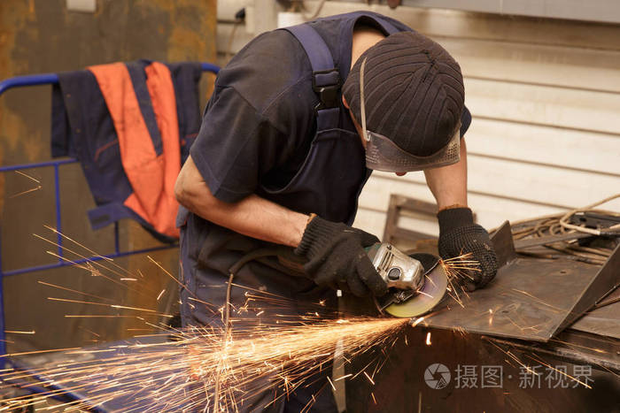 磨床工人切割金属的特写镜头而磨铁的火花