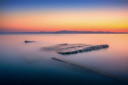 美丽令人惊叹的多彩生动日出在 Pefkochori 村庄里 Chalkidiki 希腊，长时间曝光的海景照片