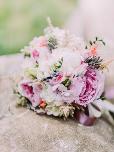 色彩缤纷的牡丹用草药放在喷泉的美丽婚礼花束
