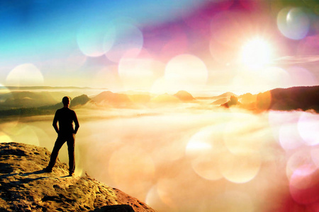 胶片颗粒。名男子站在岩石在谷内黎明和手表到热的太阳美丽时刻自然的奇迹