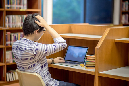 年轻的亚洲大学学生在图书馆图片