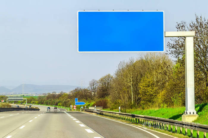 空白的蓝色高速公路标志在道路上阳光灿烂的日子