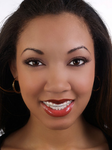 带着微笑的年轻黑人女人，上面戴着牙套