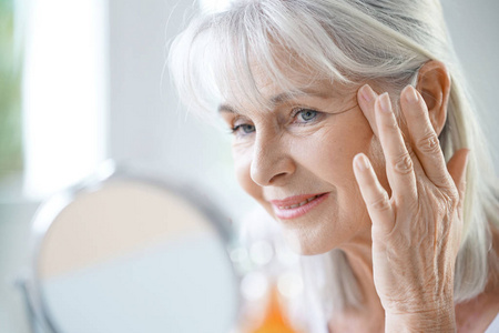 应用抗衰老面霜的女人图片