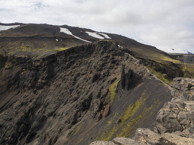 沿着长亮绿色的青苔，冰岛的火山的黑冠
