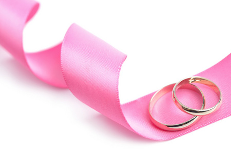 金色的结婚戒指，粉色的缎带