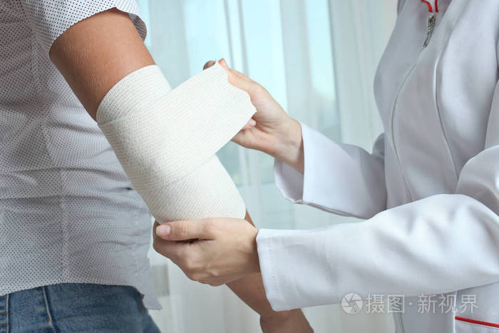 护士磨男孩的手肘与弹性绷带