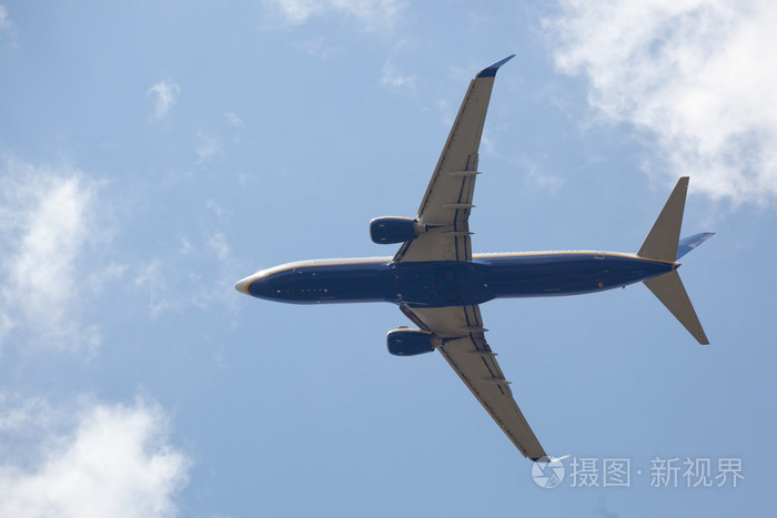 波音737飞机底部以多云的天空为背景