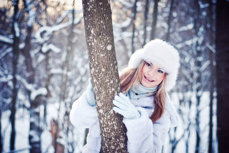 美丽的女孩在一个下雪的冬天公园