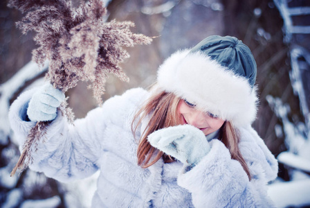 美丽的女孩在一个下雪的冬天公园