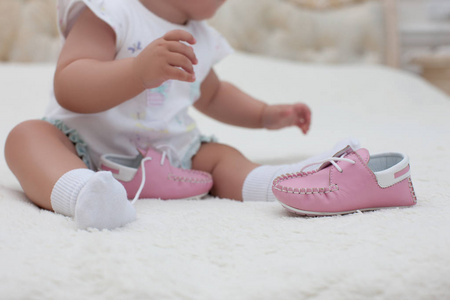 婴儿的女孩穿着粉红色的鞋子