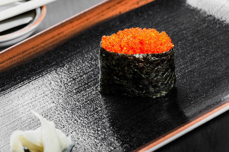 配上深色的木质背景鲑鱼鱼子酱寿司京坎费工。日本料理。顶视图