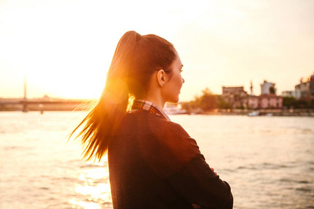 年轻漂亮的女孩在日落时旁边为背景，伊斯坦布尔博斯普鲁斯海峡。土耳其。休息休假