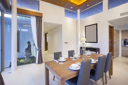 豪华室内设计在泳池别墅的客厅里。高明亮又通风空间提出天花板和木餐桌