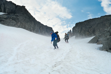 登山者在雪地上走在山顶上。