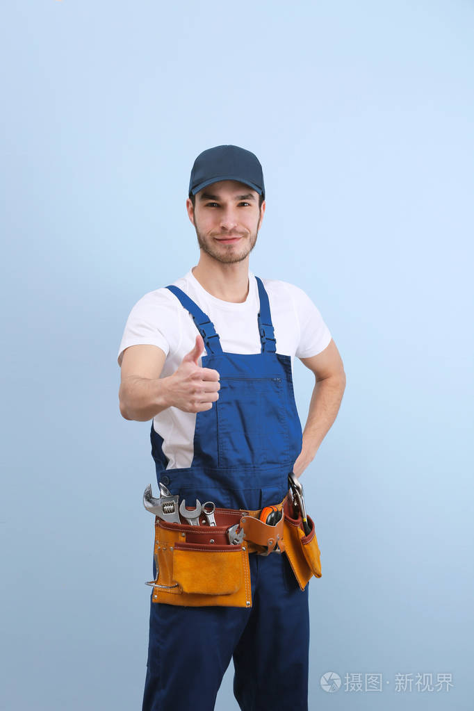英俊的年轻管道工在制服颜色背景