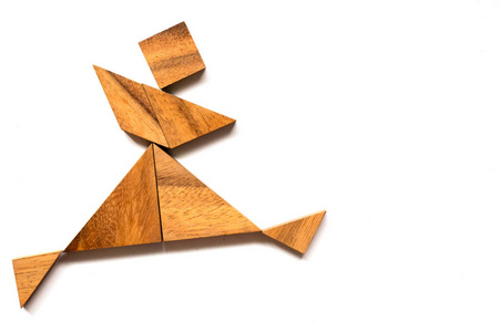 在白色背景上跳舞的人形木制七巧板拼图照片