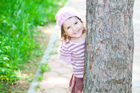 躲在树后面的小女孩