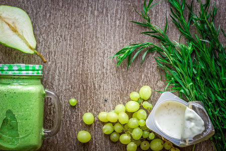 健康的绿色果汁菠菜放在杯子里对木制背景