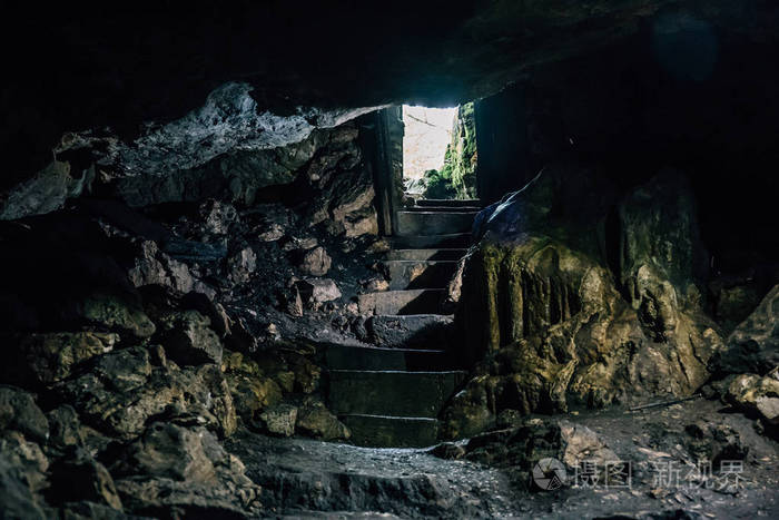 黑暗的山洞里,从入口楼梯和光的步骤