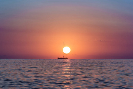 太阳升起在海洋与浮在太阳船照片
