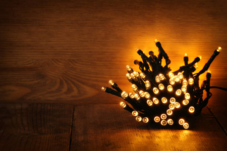 圣诞温暖金花环灯木制仿古背景上。已过滤的图像