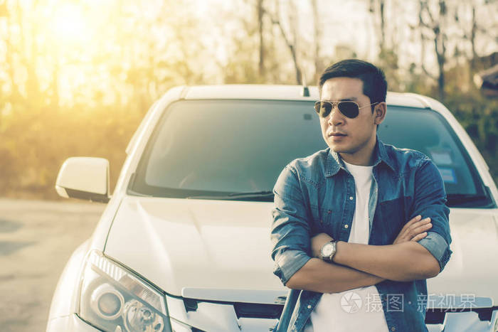 成功的年轻男人站在车旁
