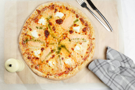 比萨意大利与大马哈鱼在纸上。餐巾，刀和叉在一家餐馆